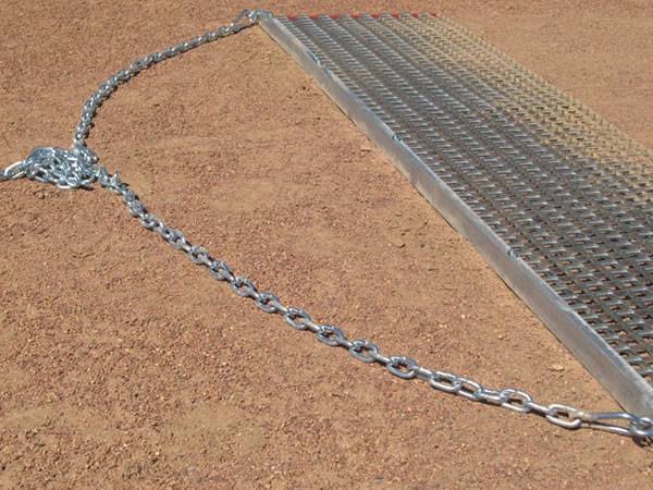 Heavy duty drag mat with tow chain which connects tractor and mat together